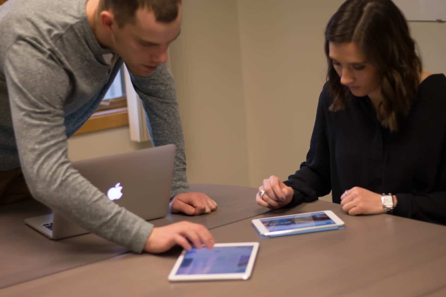 Man and woman looking at ipads